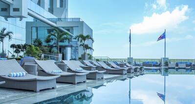 Outdoor Pool, Lounge Chairs and Windowed Side of Hotel