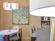 King suite dining area with dining table, chairs, counter-top with high chairs, and art displayed on the wall