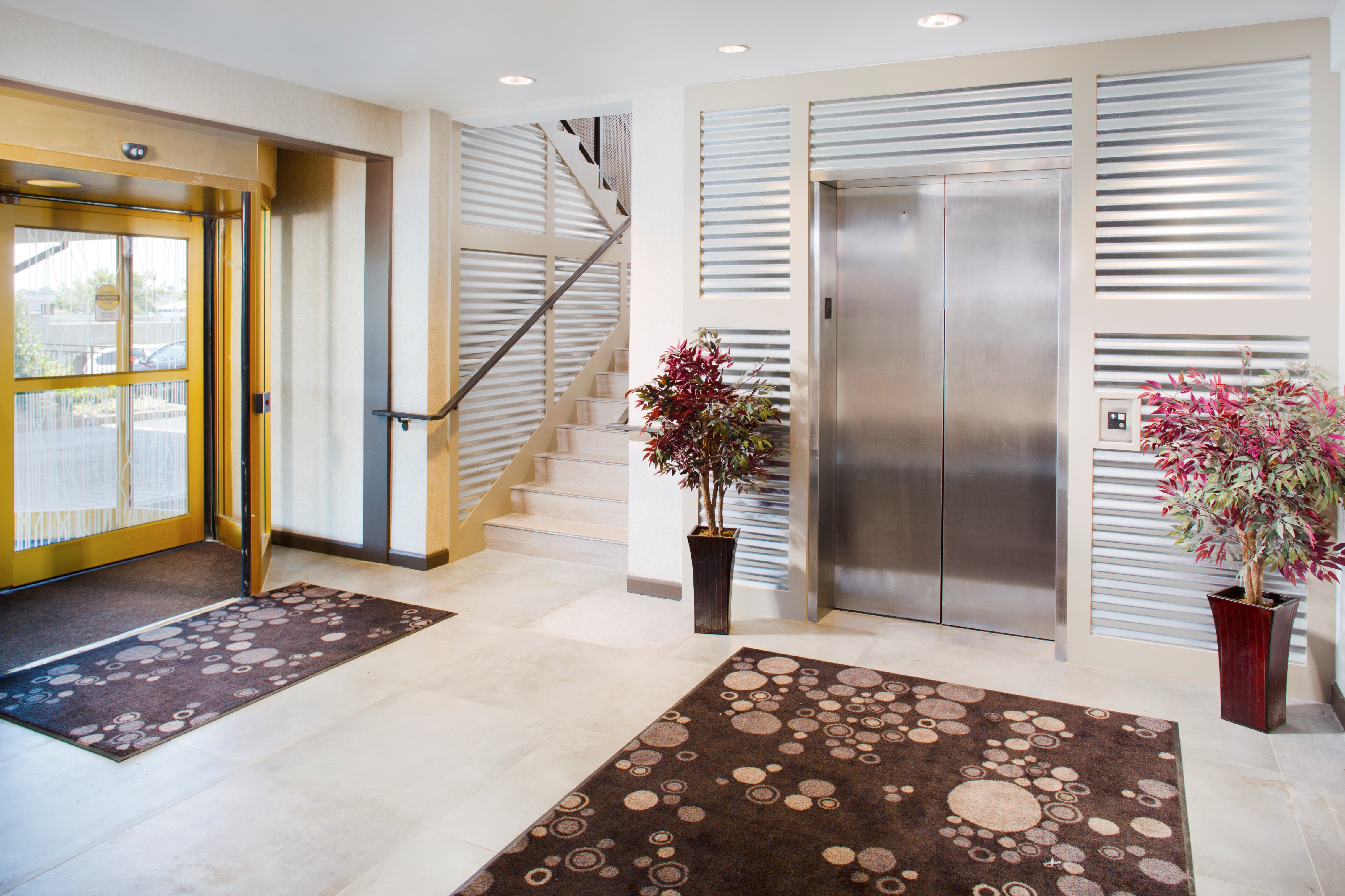 Glass Door Entrance, Elevator, and Staircase in Lobby