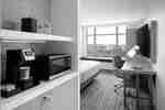 Guest room with a bed, work desk, TV, microwave, and mini fridge beside a window