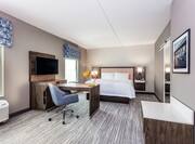 One King Bed Guest Suite with Wall Mounted TV and Work Desk
