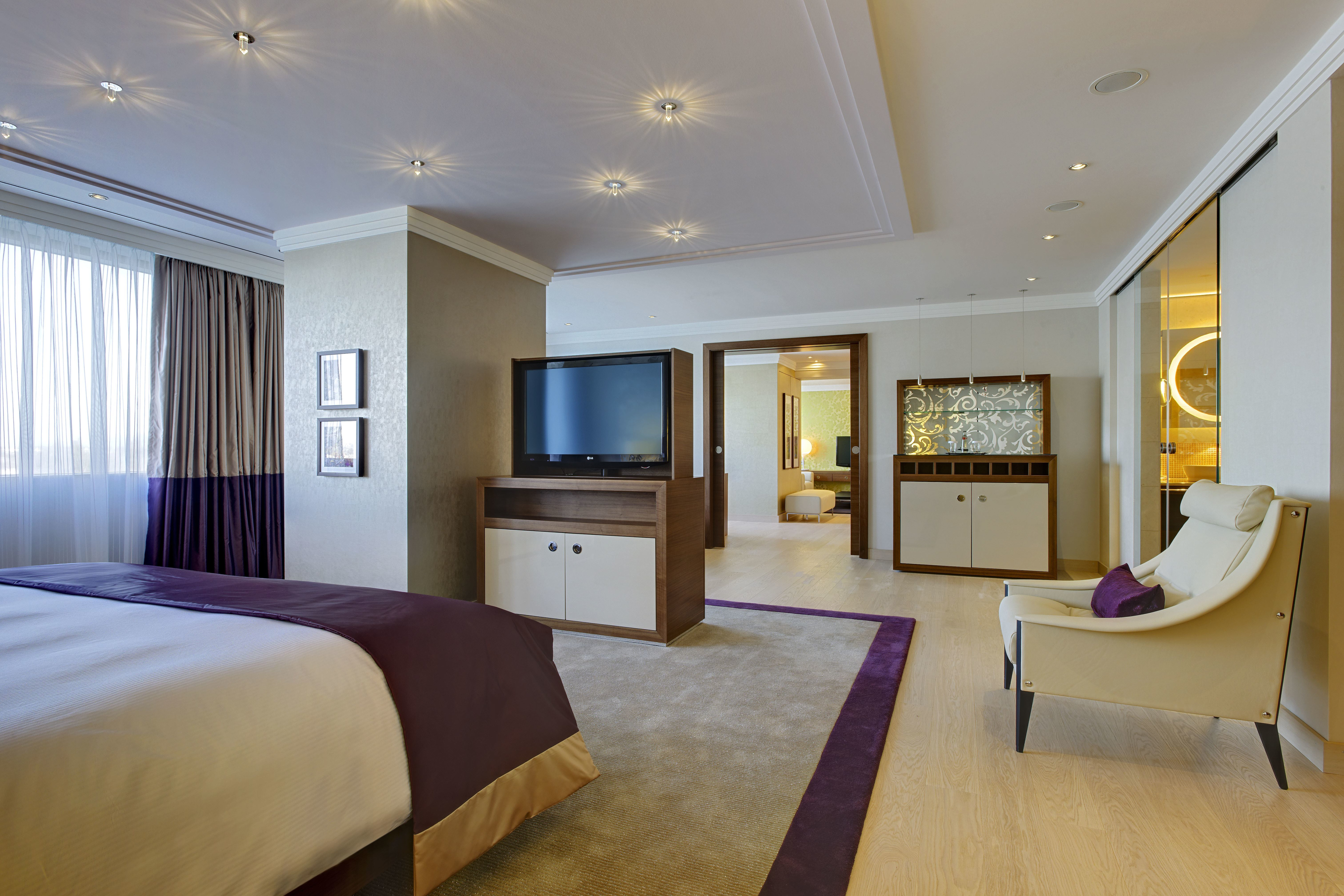 Large Bed HDTV and Armchair in Presidential Suite