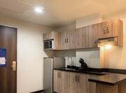 1 King Suite Kitchen With Microwave, Fridge, Sink and View of Entry