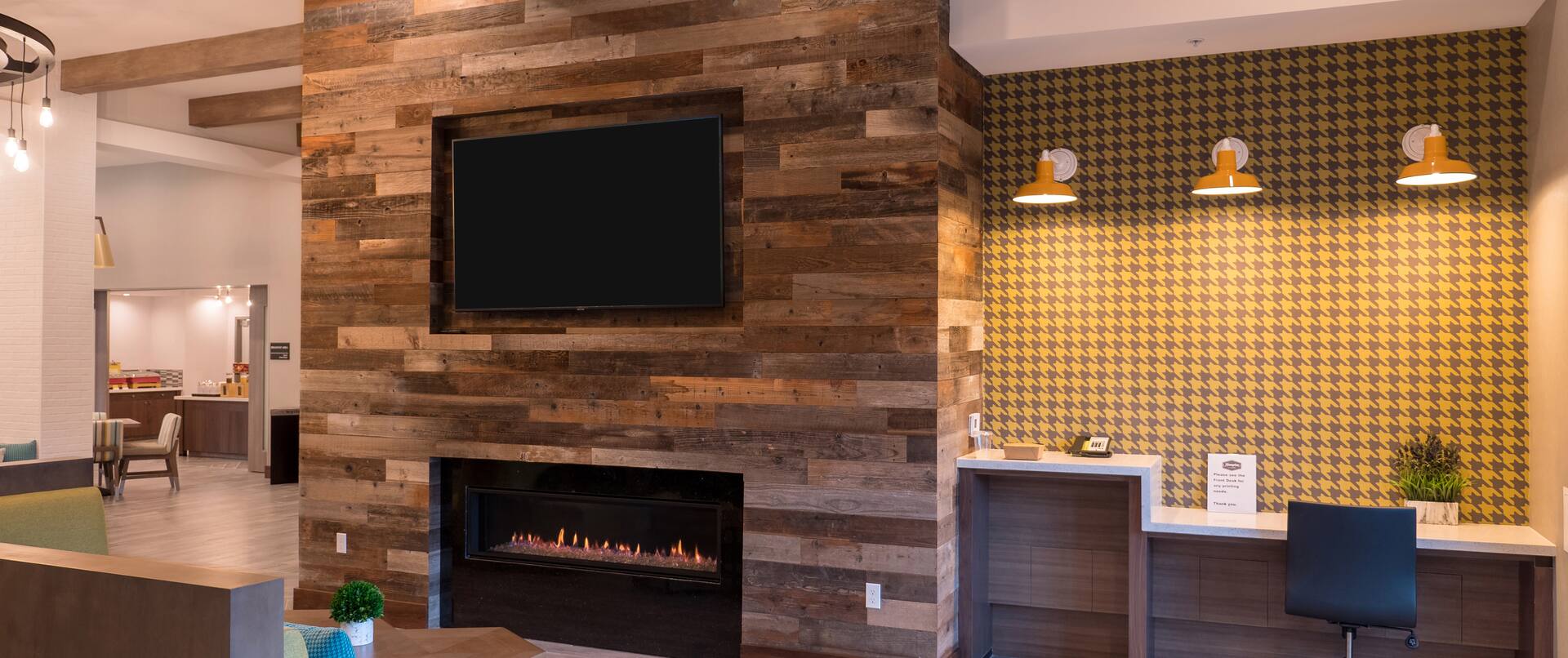 Front Desk Reception Area with Wall-Mounted TV and Fireplace