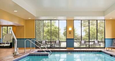 Indoor Pool with Surrounding Windows and Lounge Chairs