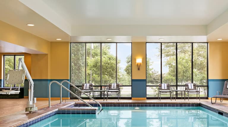 Indoor Pool with Surrounding Windows and Lounge Chairs