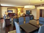 Presidential Suite Living Area with Lounge Seating, Television and Dining Table