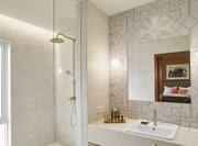 King Deluxe Room Bathroom with Walk-in Shower, Vanity, and Amenities 