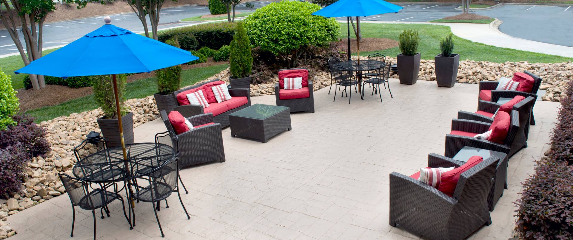 Tables With Umbrellas, and Soft Seating on Patio by Parking Lot