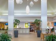 Decorative Lighting, Beverage Station, and Plants in Lobby With View of Front Desk and Snack Shop