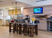 Hot and Cold Buffet Selections in Breakfast Area With Plates, Utensils, and Beverages