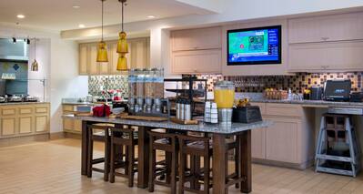 Hot and Cold Buffet Selections in Breakfast Area With Plates, Utensils, and Beverages
