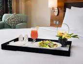 Tray of Room Service on Neatly Made Bed