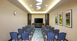 Al Wadi Meeting Room Arranged Theater Style With Rows of Blue Chairs Facing TV