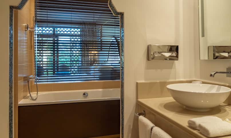 Toilettentischbereich und Badewanne im Zimmer mit Kingsize-Bett und Gartenblick – frühere Umstellung
