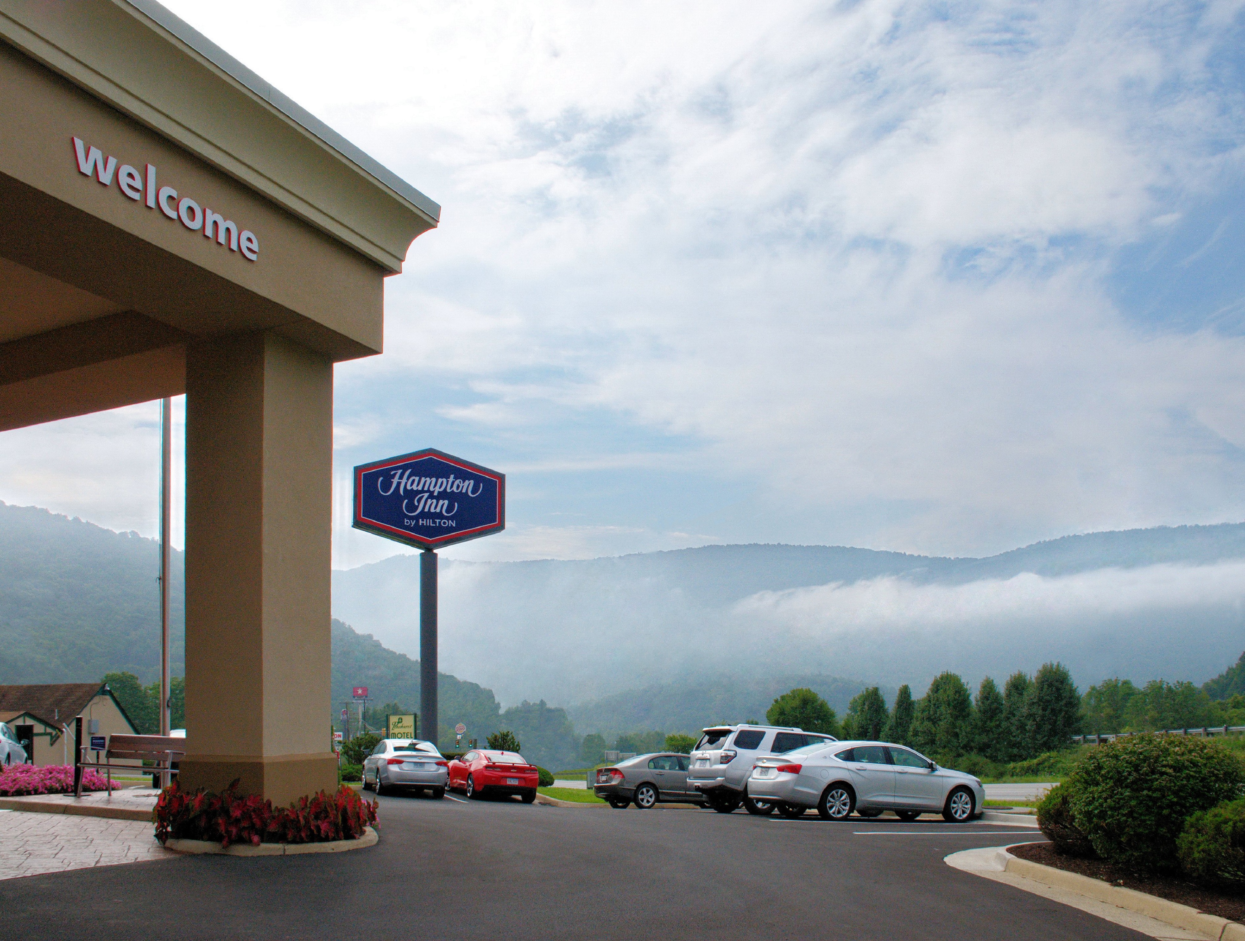 Side View of Hotel Exterior, Parking Lot and Mountain View
