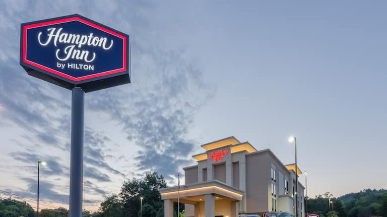 Hotel Building Exterior with Hampton Inn by Hilton Sign at Sunset