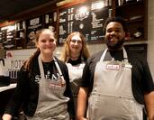 3 Baristas in Front of the STEAM Coffee Menu