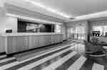 Hotel lobby reception area with a long front desk and modern seating.