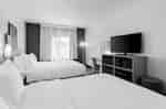 Alternate view of the two-queen room showing the beds, television, and window.