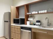 Spacious accessible kitchen fully equipped with full size refrigerator, dishwasher, microwave, and coffee maker.