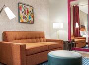 Bright lounge area in studio suite featuring comfortable sofa and stylish design.