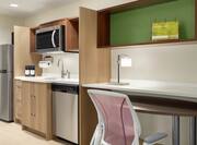 Spacious studio suite featuring fully equipped kitchen and work desk.