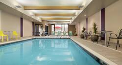 Spacious indoor swimming pool featuring large windows, ample seating, and accessible chair-lift.