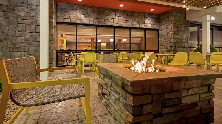 Spacious outdoor patio for guests to relax featuring ample seating and cozy fire pit.