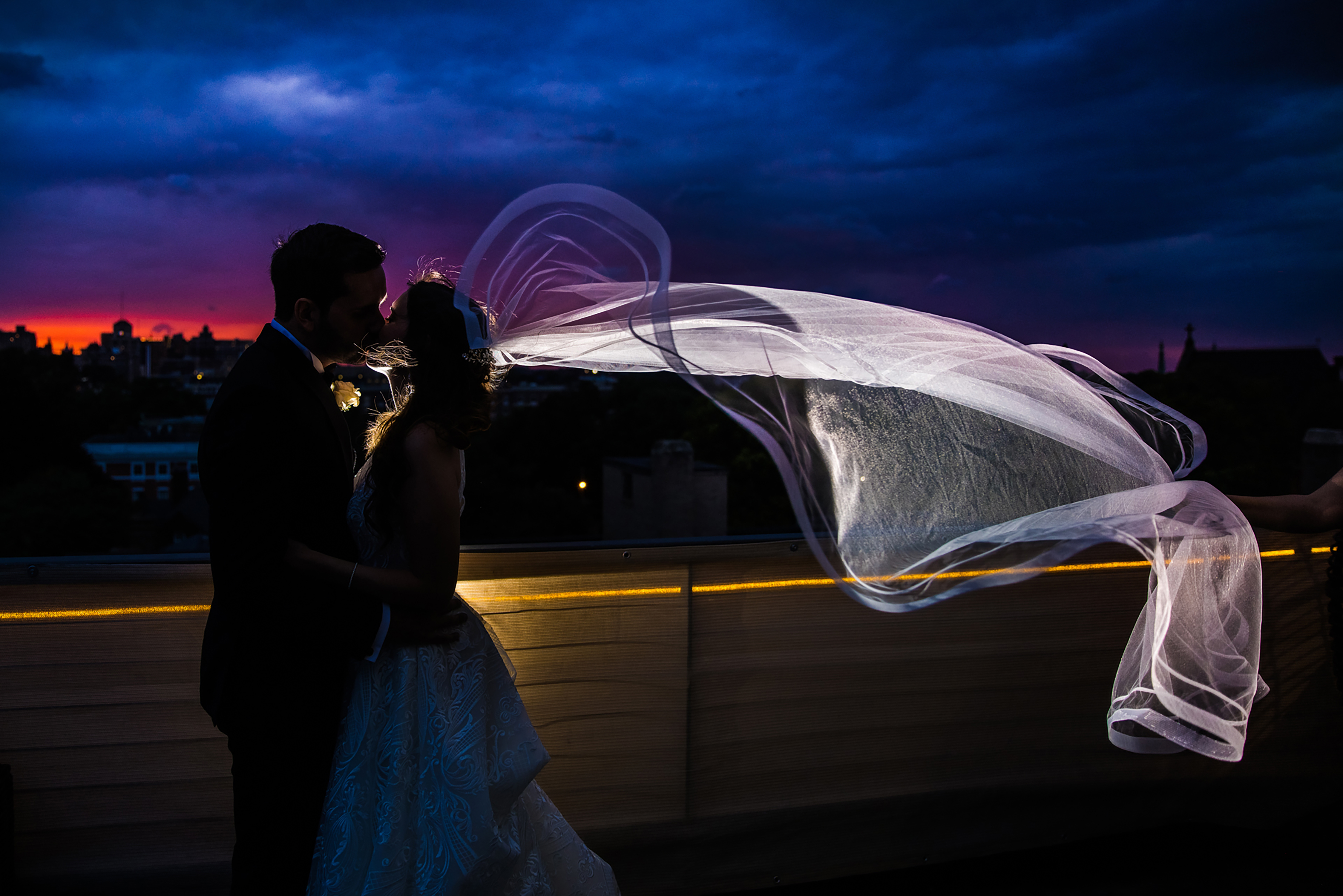 Wedding Couple Kissing on a Balcony at Night