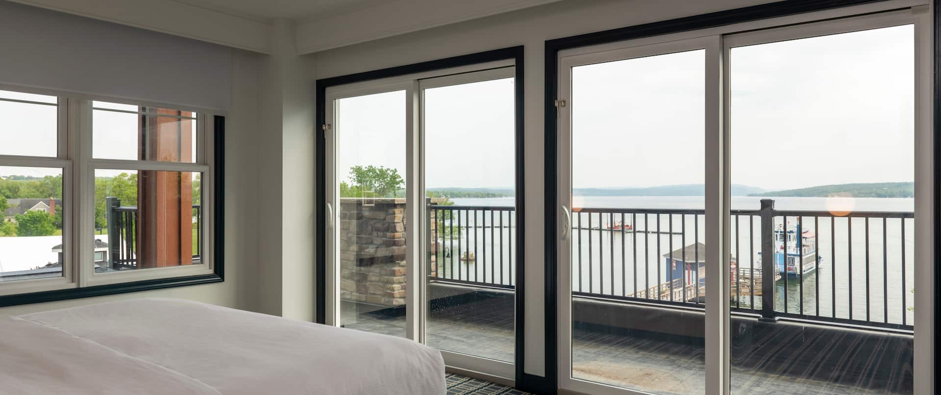 Bed in room with view of lake