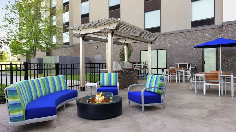 Beautiful outdoor patio featuring bbq grill, comfortable seating, and firepit for guests to enjoy.