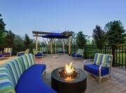 Beautiful outdoor patio at dusk featuring gazebo, ample seating, and firepit.