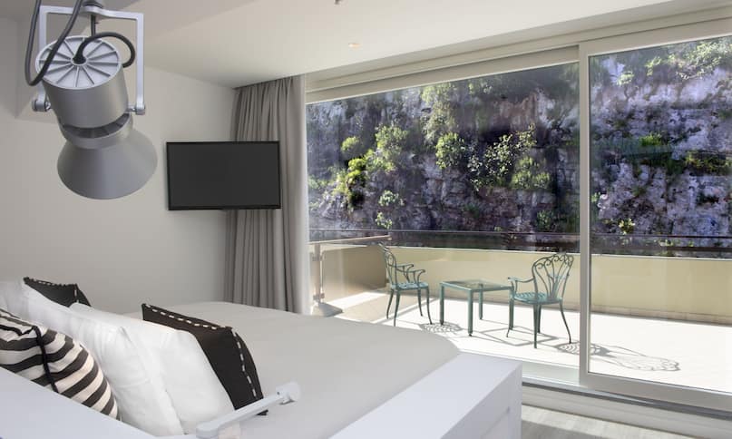 Guestroom with Bed, Wall Mounted Television, Outside View and Balcony