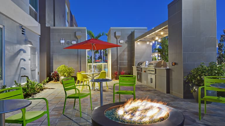 outdoor patio with firepits and barbeques at dusk