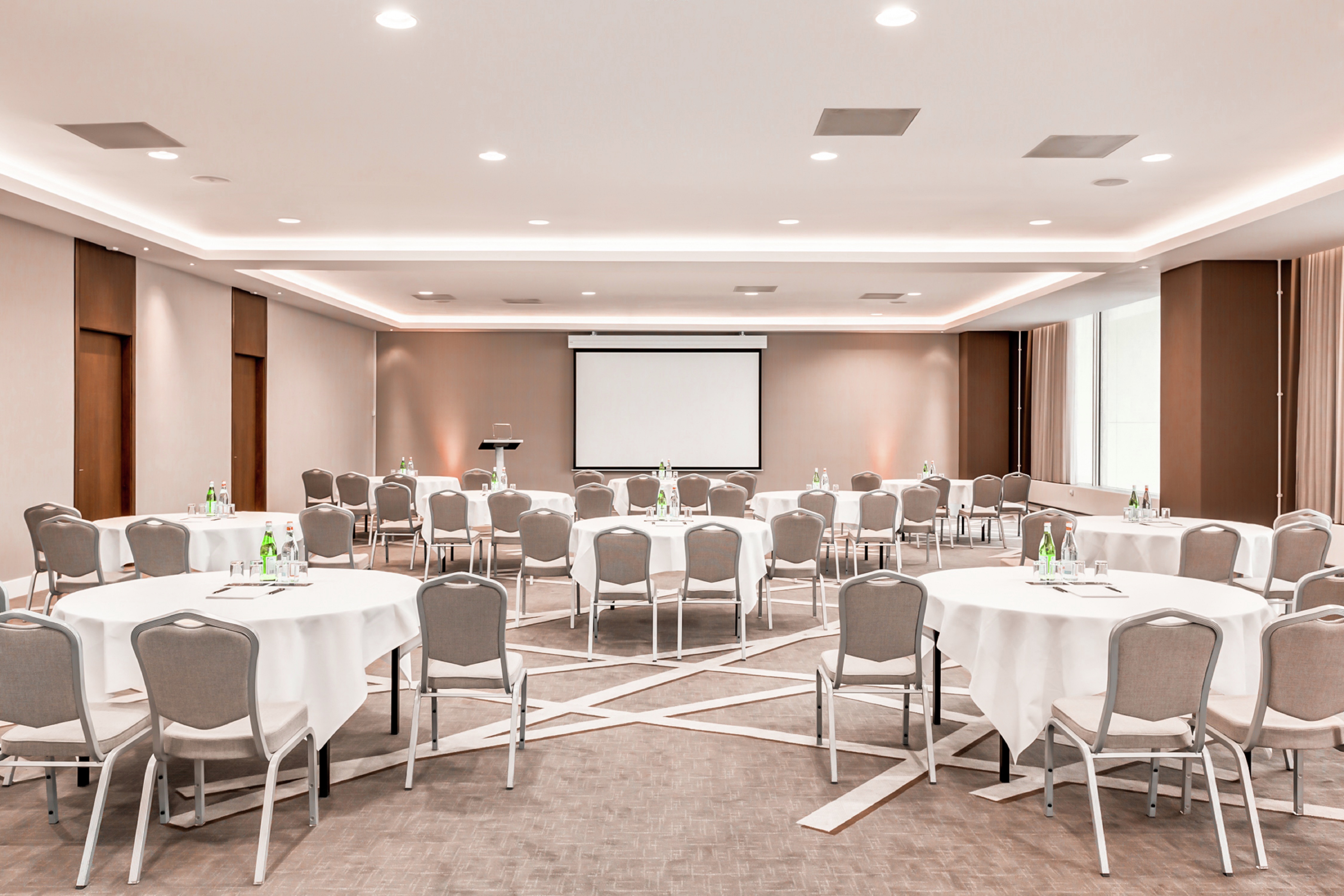 Meeting Room Setup with Round Tables and a Projection Screen