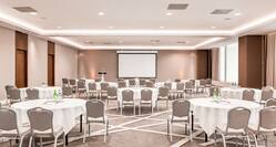 Meeting Room Setup with Round Tables and a Projection Screen