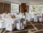 Tables and chairs with white covers set up banqueting style