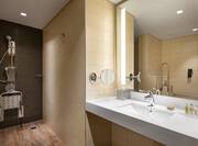 Accessible bathroom with roll-in shower and seat which can be stored away
