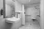Bathroom with roll-in shower, sink and mirror