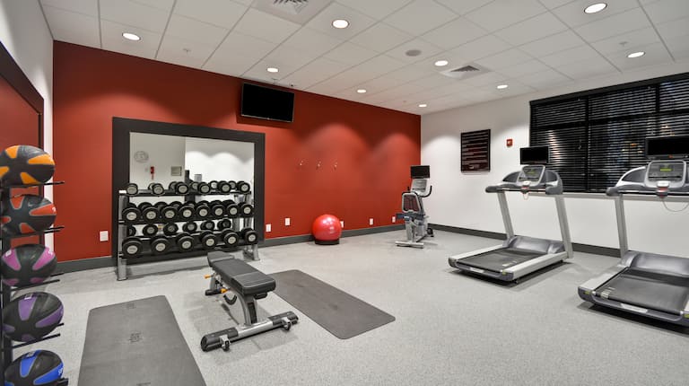 Spacious Fitness Center Space With Weights, TV, and Cardio Equipment