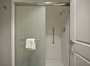 Open Bathroom Door to View of Shower With Glass Doors in Suite