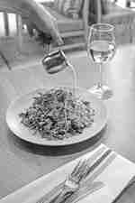 Saus dituangkan di atas hidangan, dengan segelas anggur