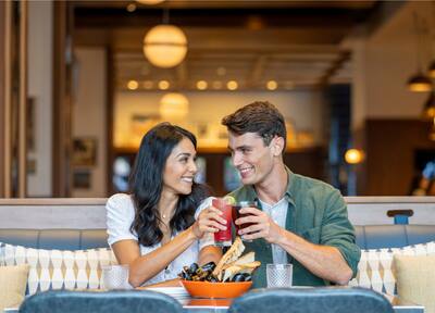 A Couple Enjoying a Drink and Food at Hudson and Nash Restaurant