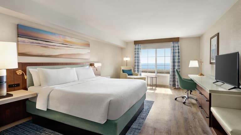Spacious guestroom featuring comfortable king bed, work desk, and stunning oceanview.