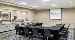 Spacious on-site meeting room featuring U shape table, projector screen, and delicious coffee break spread.