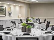 Spacious on-site meeting room featuring ample round tables with seating and stunning decorating.