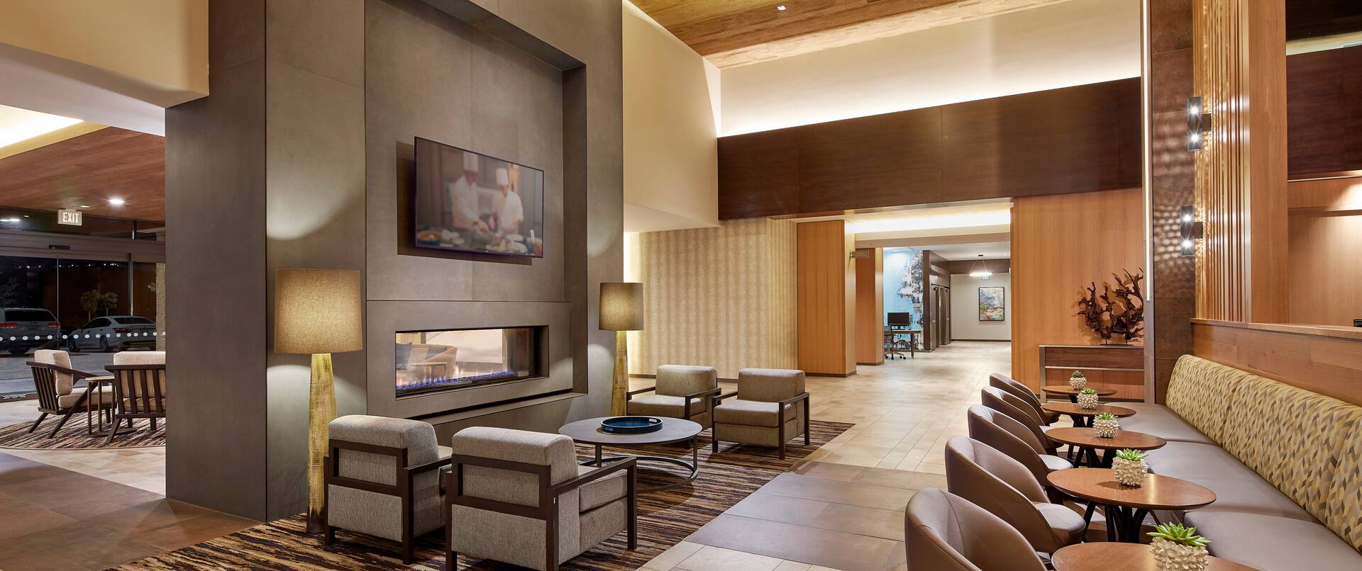 Two-sided Fireplace in the Lobby with Accent Table and Soft Seating, Small Round Dining Tables with Chairs and Booth style Seating