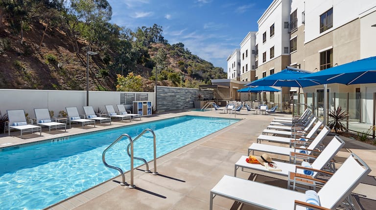 View of the Outdoor Heated Pool with Lounge Chairs and Patio Umbrellas 