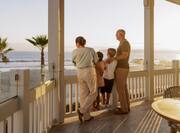 adults and children standing on guest room balcony